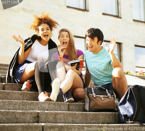 Image of cute group of teenages at the building of university with books 