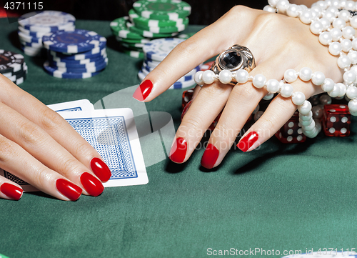 Image of hands of young caucasian woman with red manicure at casino table