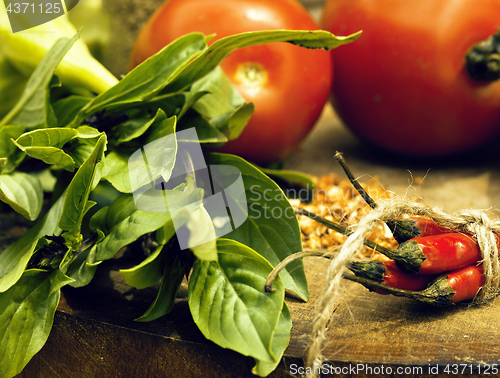 Image of vegetables on wooden kitchen with spicies, tomato, chilli, green