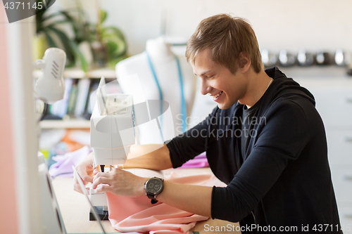 Image of fashion designer with sewing machine working