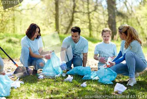 Image of volunteers with garbage bags cleaning park area