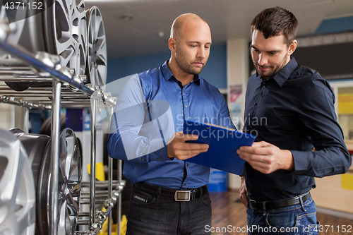 Image of customer and salesman at car service or auto store