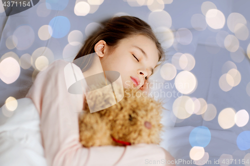 Image of girl sleeping with teddy bear toy in bed