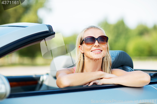 Image of happy young woman in convertible car