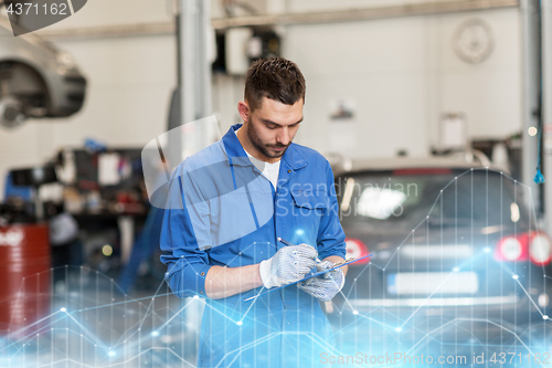 Image of auto mechanic man with clipboard at car workshop