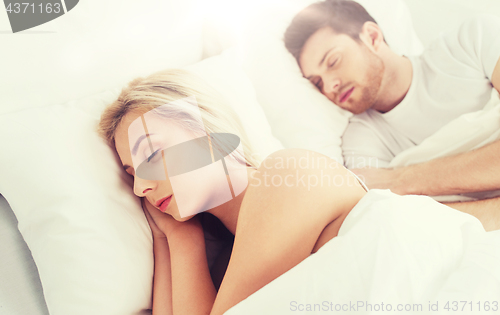 Image of happy couple sleeping in bed at home