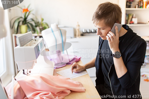 Image of fashion designer calling on smartphone at studio