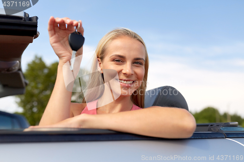 Image of happy young woman with convertible car key