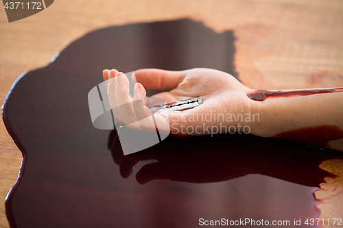 Image of dead woman hand in blood on floor at crime scene