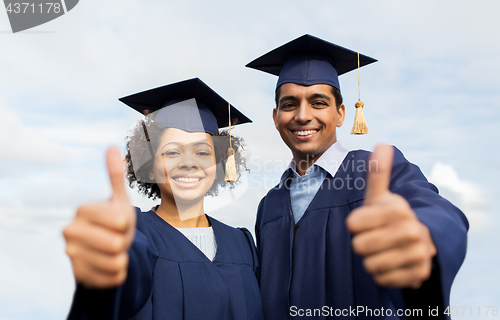 Image of happy students or bachelors showing thumbs up