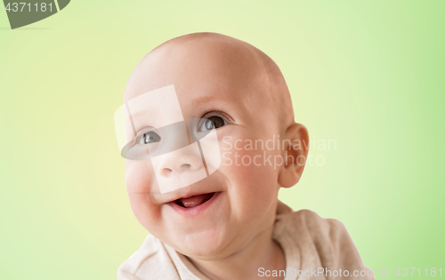 Image of close up of happy little baby boy over green