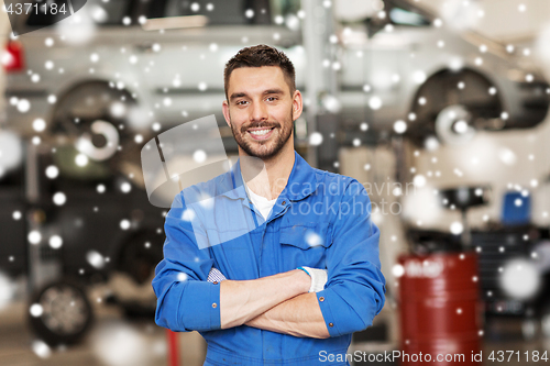 Image of happy auto mechanic man or smith at car workshop