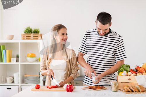 Image of happy couple cooking food at home kitchen