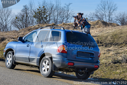 Image of Photographer takes pictures from the car