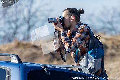 Image of Photographer takes pictures from the car