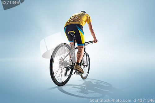 Image of The bicyclist on gray, studio shot.