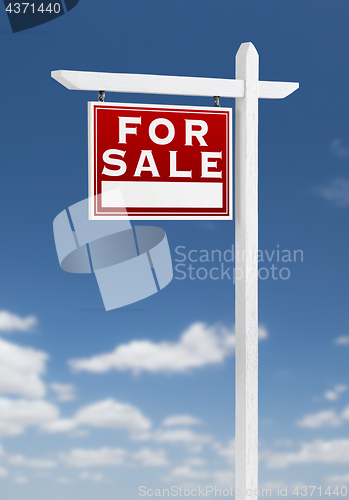 Image of Left Facing For Sale Real Estate Sign on a Blue Sky with Clouds.