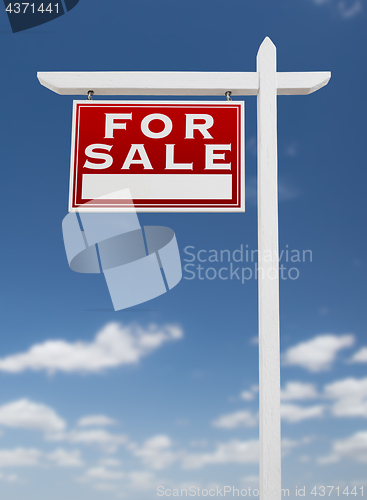 Image of Left Facing For Sale Real Estate Sign on a Blue Sky with Clouds.