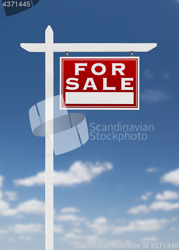 Image of Right Facing For Sale Real Estate Sign on a Blue Sky with Clouds