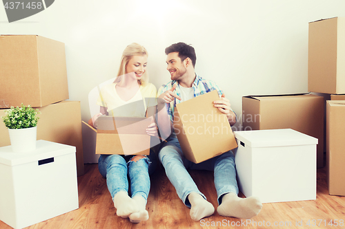 Image of smiling couple with many boxes moving to new home