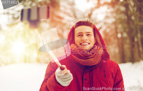 Image of happy man taking selfie by smartphone in winter