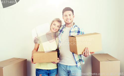 Image of smiling couple with big boxes moving to new home