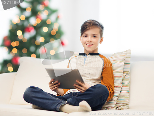 Image of smiling boy with tablet pc at home at christmas