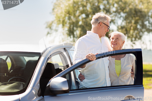 Image of happy senior couple with car in summer