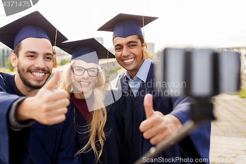 Image of students or graduates taking selfie by smartphone