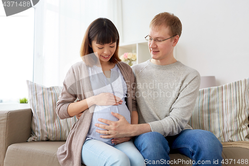 Image of happy pregnant wife with husband at home