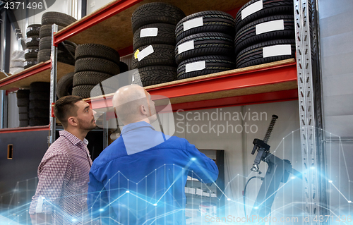 Image of mechanic and man choosing tires at car shop