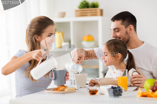 Image of happy family having breakfast at home