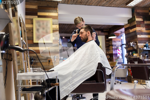 Image of man and barber cutting hair at barbershop