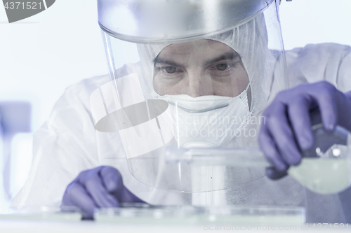 Image of Life scientist researching in bio hazard laboratory. High degree of protection work.