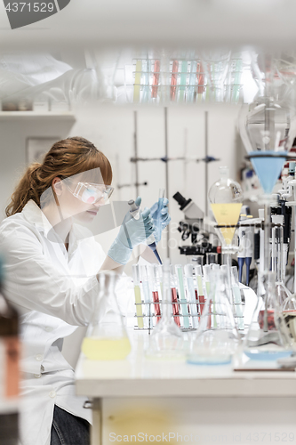 Image of Young scientist pipetting in life science laboratory.