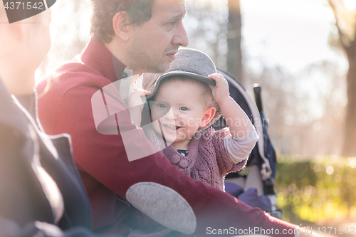 Image of Young family with cheerful child in the park.