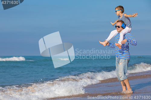 Image of Father and son playing on the beach at the day time. Concept of 