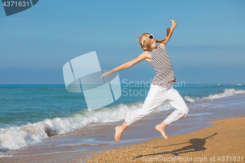 Image of One happy little girl playing on the beach at the day time
