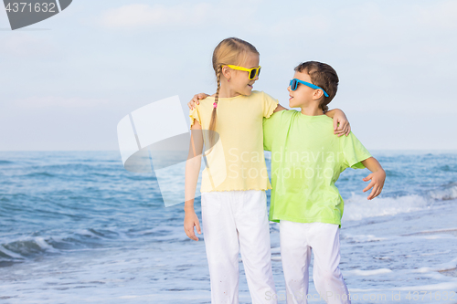 Image of Two happy children playing on the beach at the day time