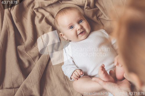 Image of mom dresses the baby on the bed