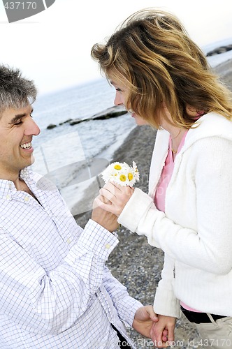 Image of Mature romantic couple with flowers