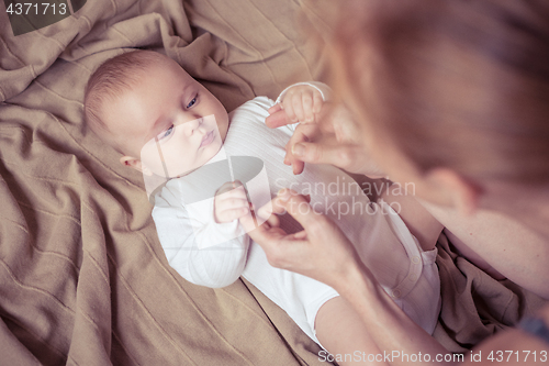 Image of mom dresses the baby on the bed