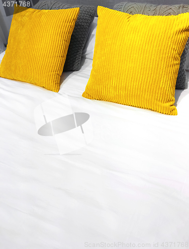 Image of Bed with bright yellow velveteen cushions