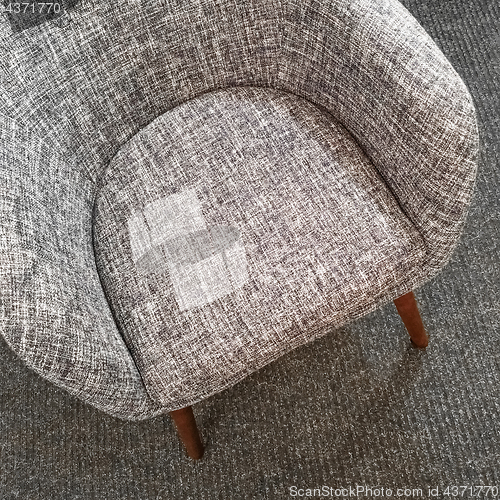Image of Stylish gray armchair on carpet floor