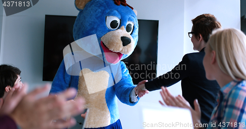 Image of boss dresed as bear having fun with business people in trendy of