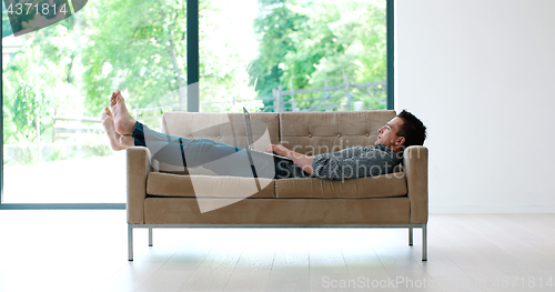 Image of Man using laptop in living room