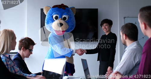 Image of boss dresed as bear having fun with business people in trendy of