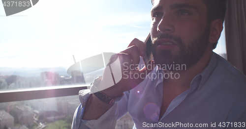 Image of Business Man Talking On Cell Phone At Home