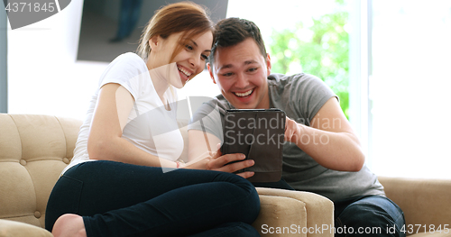 Image of Young Couple using digital tablet at home
