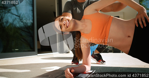 Image of Couple Doing Stretching Exercises Together in front of luxury vi